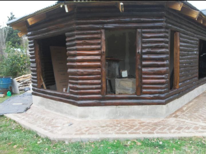 Cabaña octogonal de troncos oscuros en construccion